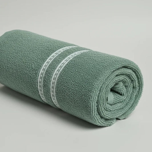 Rolled-up green towel with a white stripe on a light gray background