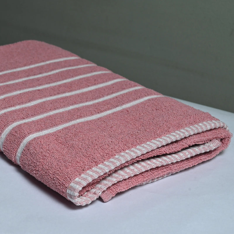 Pink towel with white stripes on a white surface