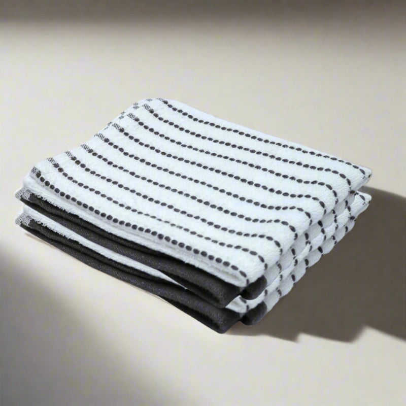 Stack of black and white patterned towels on a beige background