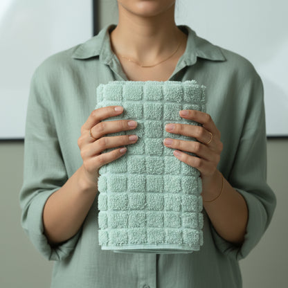 Light green towel hold by lady wearing aqua upper.