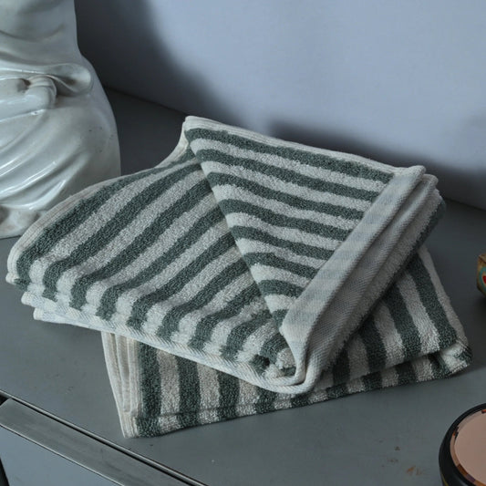 Striped towel and decorative items on a gray surface