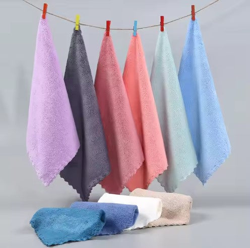 Set of colorful towels hanging on a line against a gray background