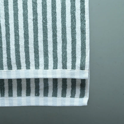 Green and white striped towel on a gray background