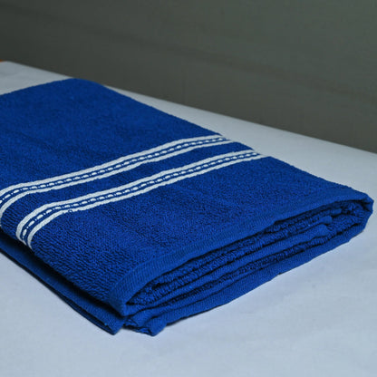 Folded blue towel with white stripes on a white surface
