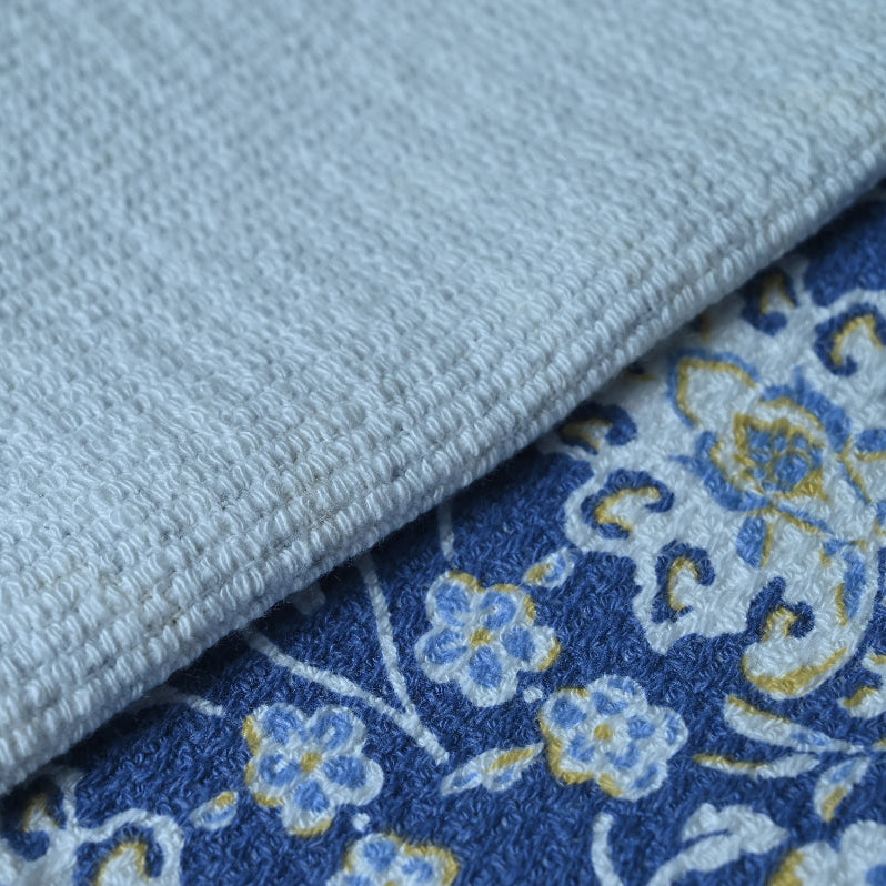 Close-up of a blue floral fabric and a light gray textured fabric.