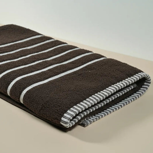 Folded brown towel with white stripes on a beige surface