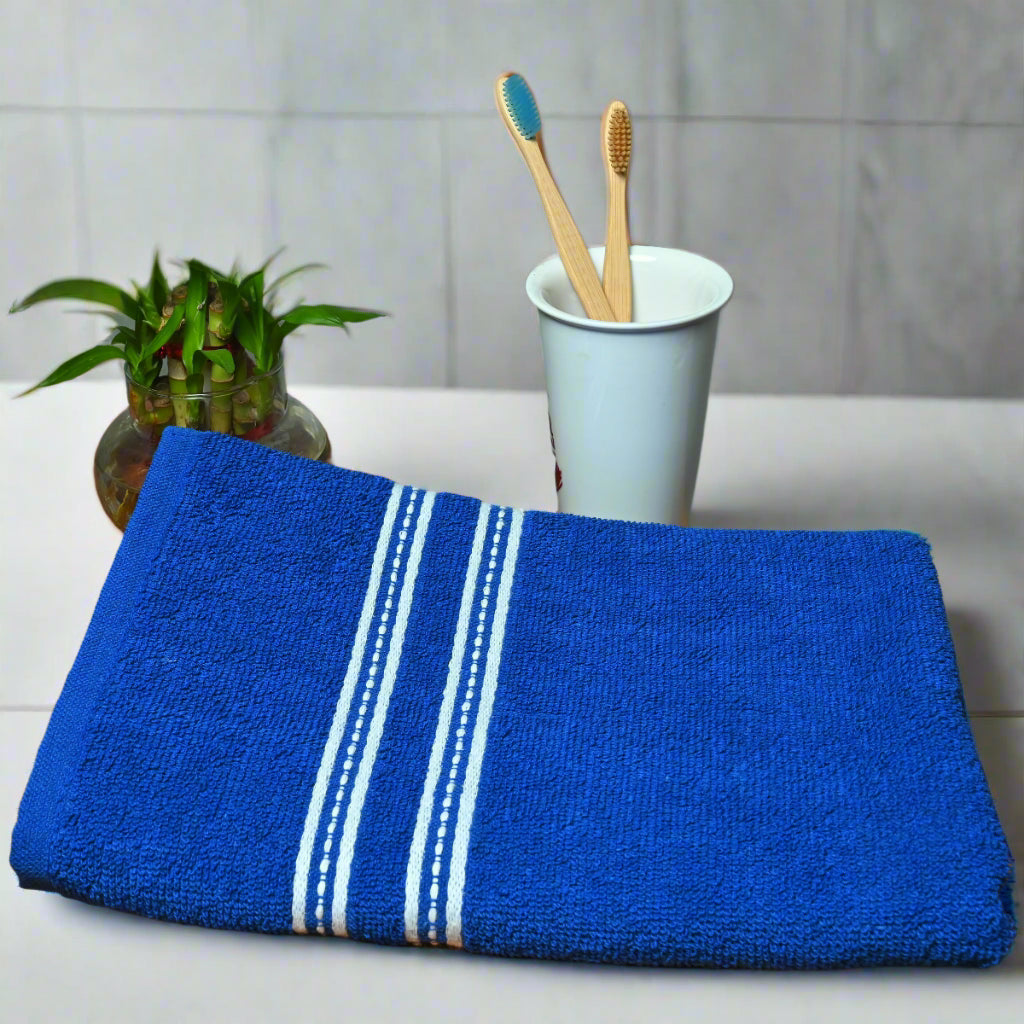 a folded blue color bath towel on a table.