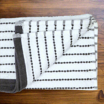 Folded black and white striped towel on a beige background
