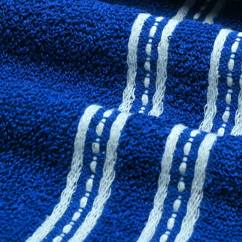 Close-up of a folded blue bath towel with white stripes.