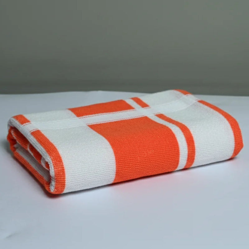 Folded orange and white striped towel on a gray background