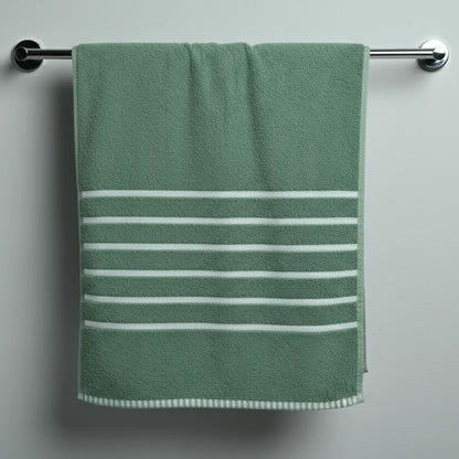 Green towel with white stripes hanging on a silver towel rack against a gray wall.