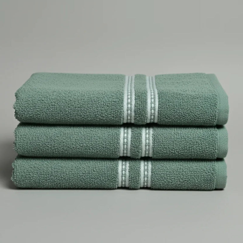 Stack of green towels with white stripes on a gray background
