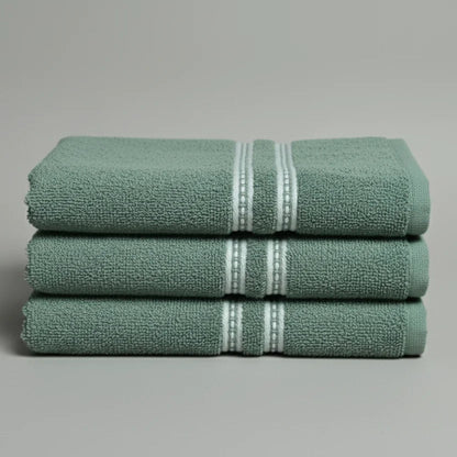 Stack of green towels with white stripes on a gray background