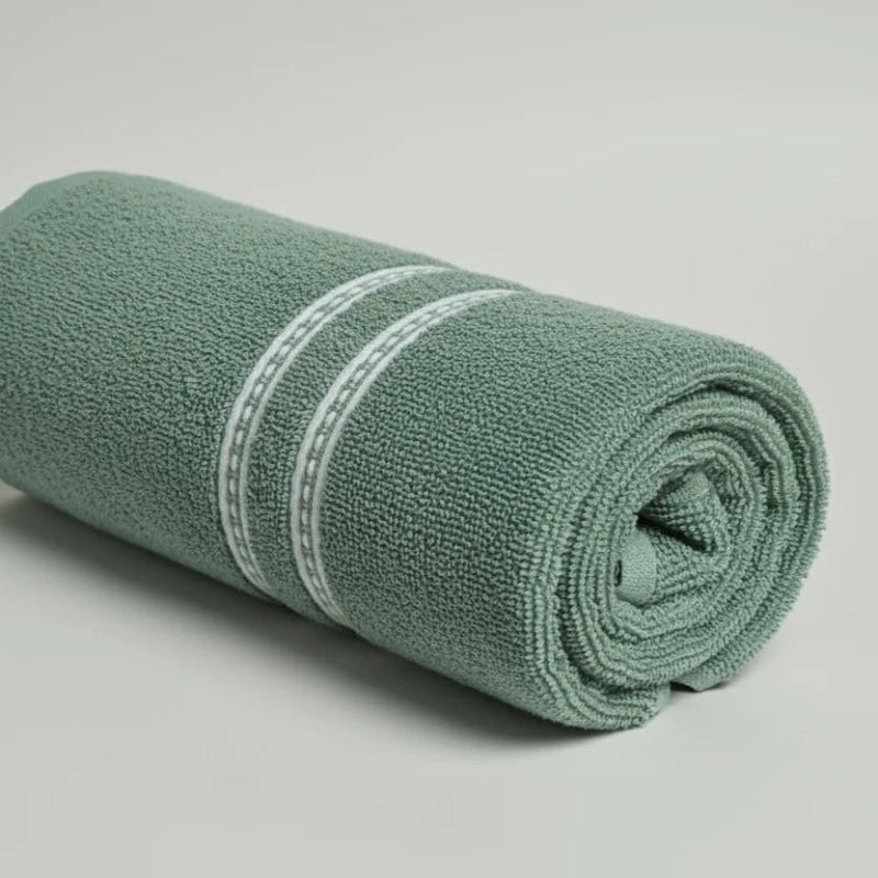 Rolled-up green towel with a white stripe on a light gray background