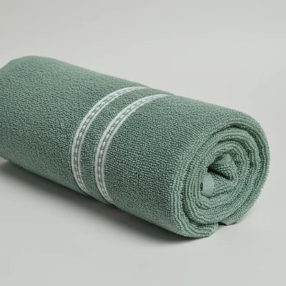 Rolled-up green towel with a white stripe on a light gray background