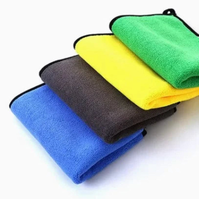 Four microfiber cloths in blue, yellow, green, and gray on a white background