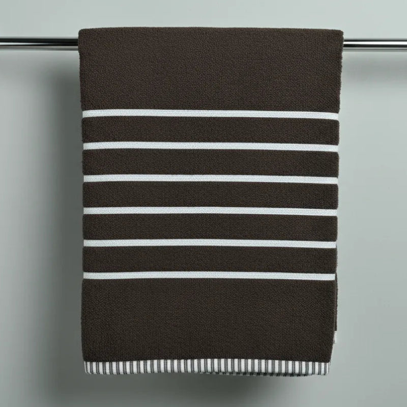 Striped towel hanging on a towel rack against a plain background