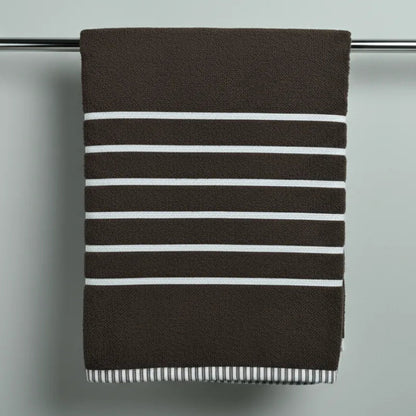 Striped towel hanging on a towel rack against a plain background