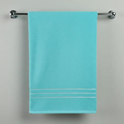 Cyan towel hanging on a silver towel rack against a gray background