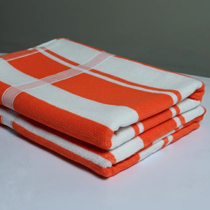 Stack of orange and white checkered towels on a gray background