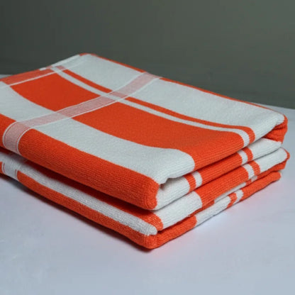 Stack of orange and white checkered towels on a gray background