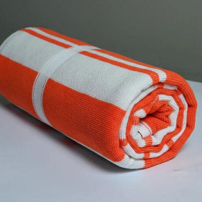 Rolled-up orange and white towel on a gray background