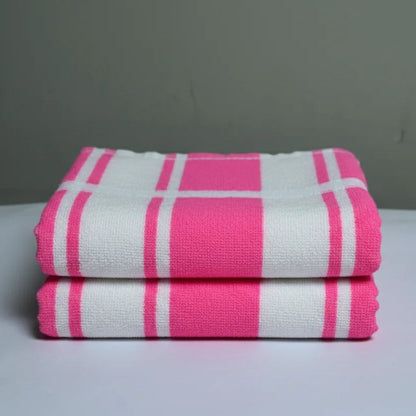 Stack of pink and white checkered towels on a gray background