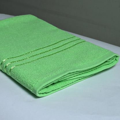 a cotton green bath towel on a white base and grey background.