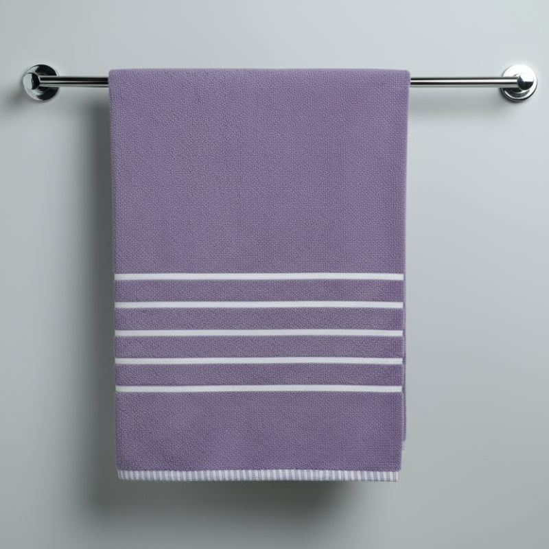 Folded purple towel with white stripes on a light surface