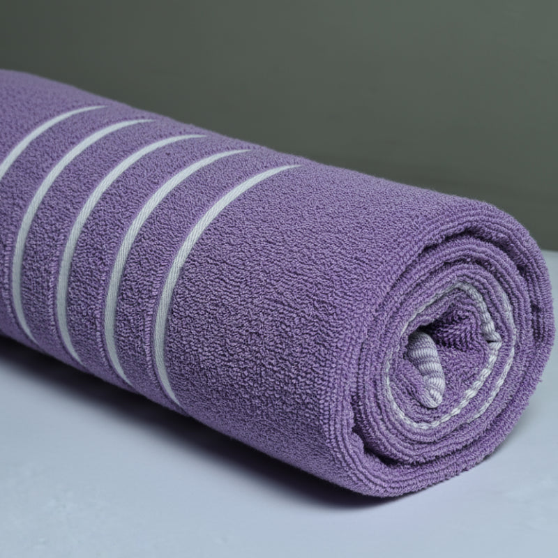 rolled purple towel with white stripes on a light surface