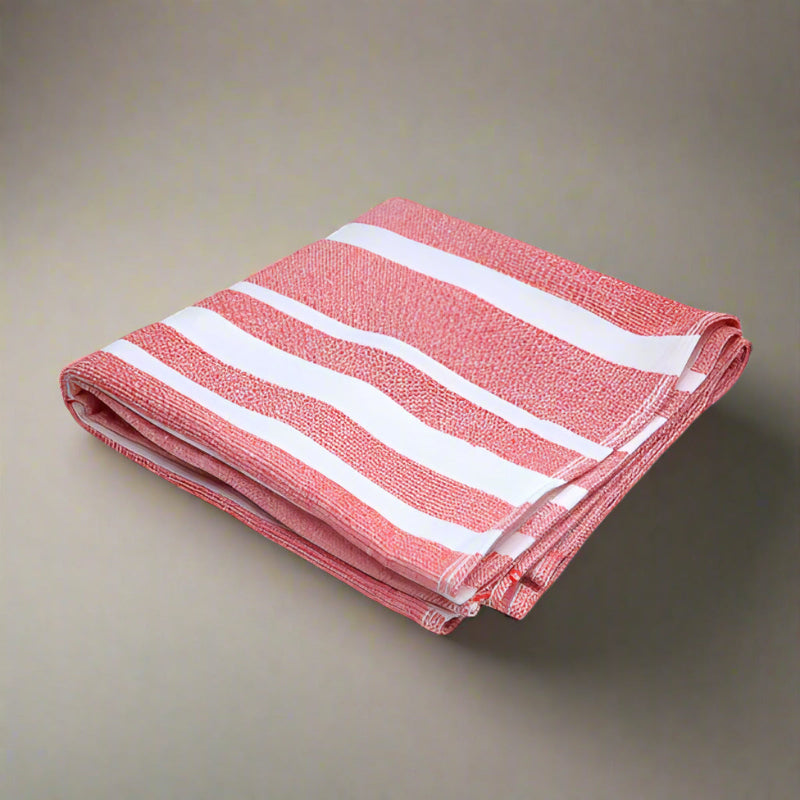 Folded red and white striped towel on a light gray background