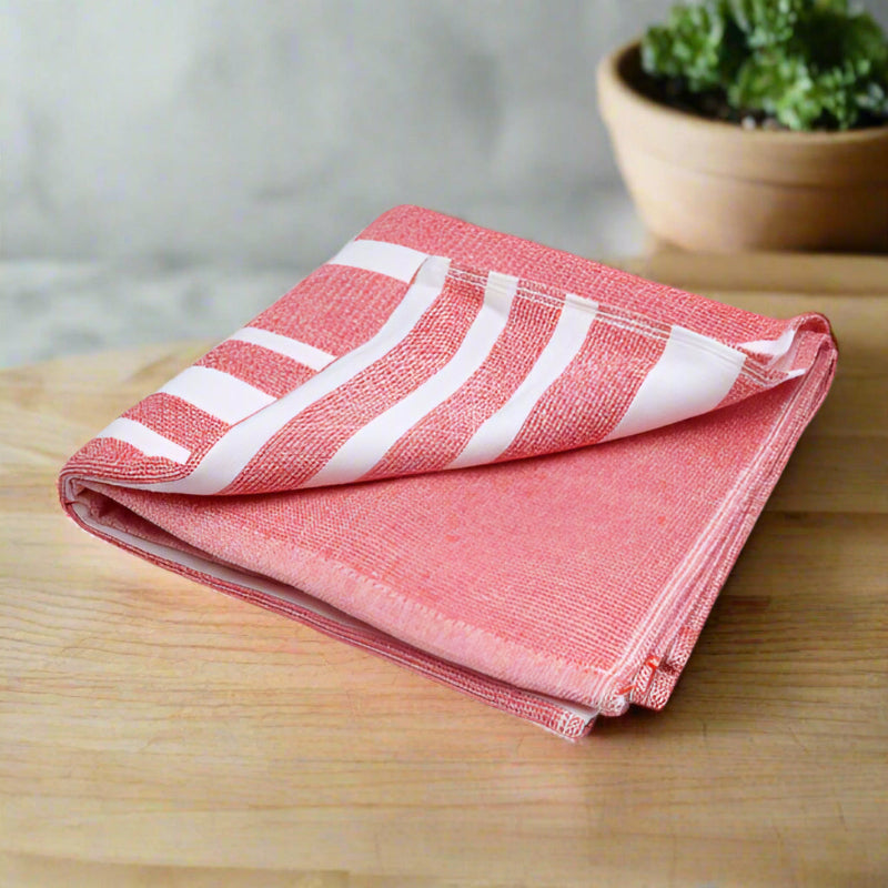 Folded red and white striped towel on a wooden background