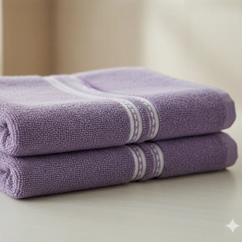 Stack of purple towels on a light surface with a blurred background