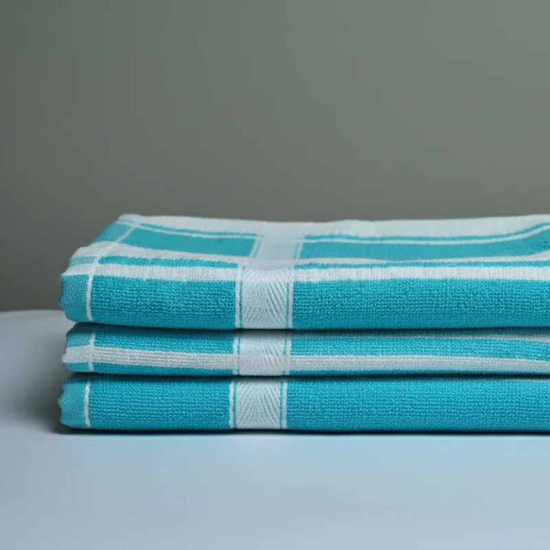 Stack of blue and white checkered towels on a gray surface with a gray background