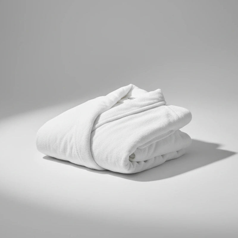 Folded white comforter on a gray background