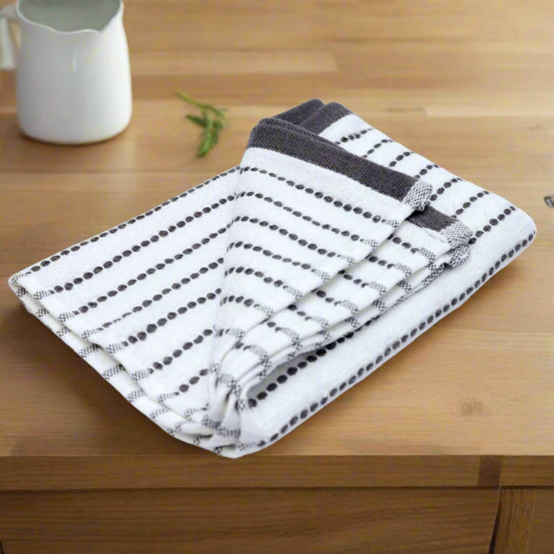 Folded black and white striped towel on a beige kitchen countertop