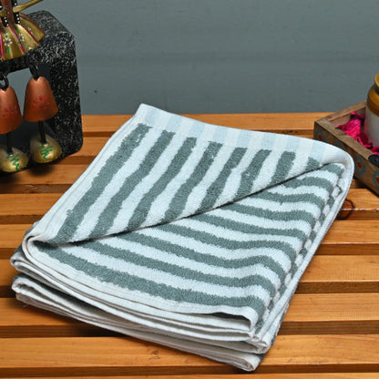Decorative items including a striped towel, figurine, and small containers on a wooden surface.