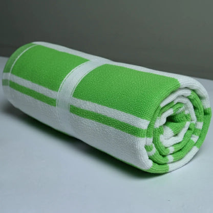 Rolled-up green and white towel on a light gray surface