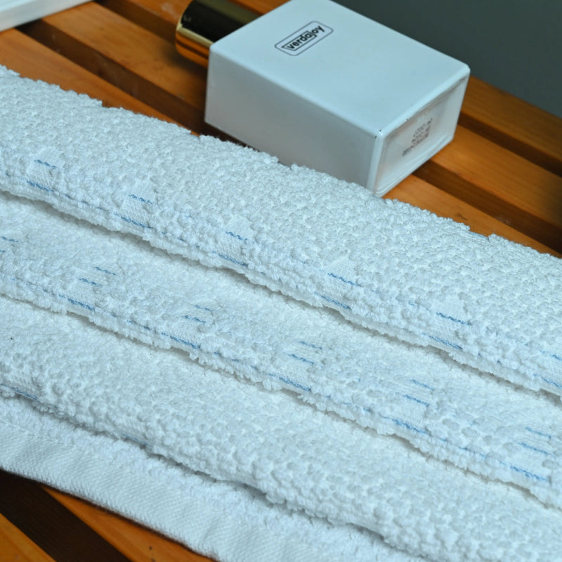 White towel on a wooden surface with a white box in the background