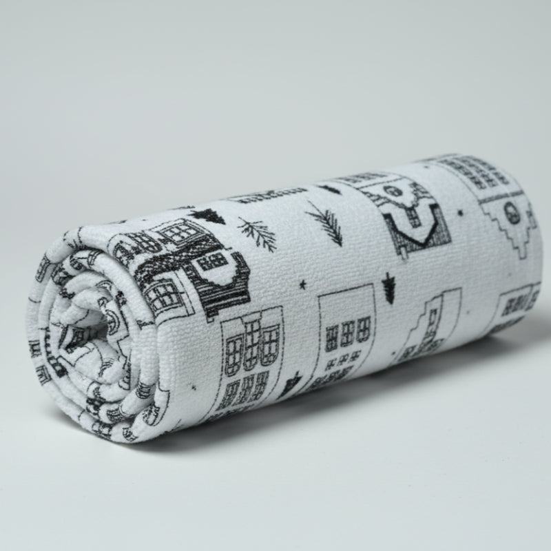 towel with house pattern on a white surface with an elephant figurine.