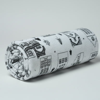 towel with house pattern on a white surface with an elephant figurine.