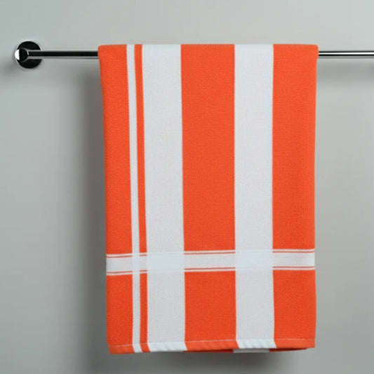 Orange and white striped towel hanging on a silver towel rack against a gray background
