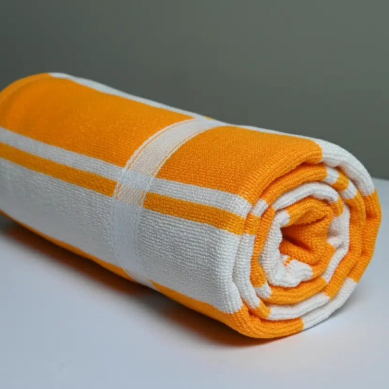 Rolled-up orange and white towel on a gray surface