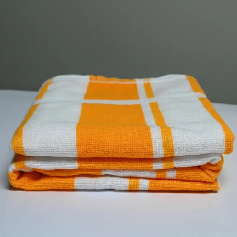 Stack of orange and white checkered towels on a gray background