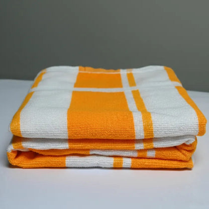 Stack of orange and white checkered towels on a gray background